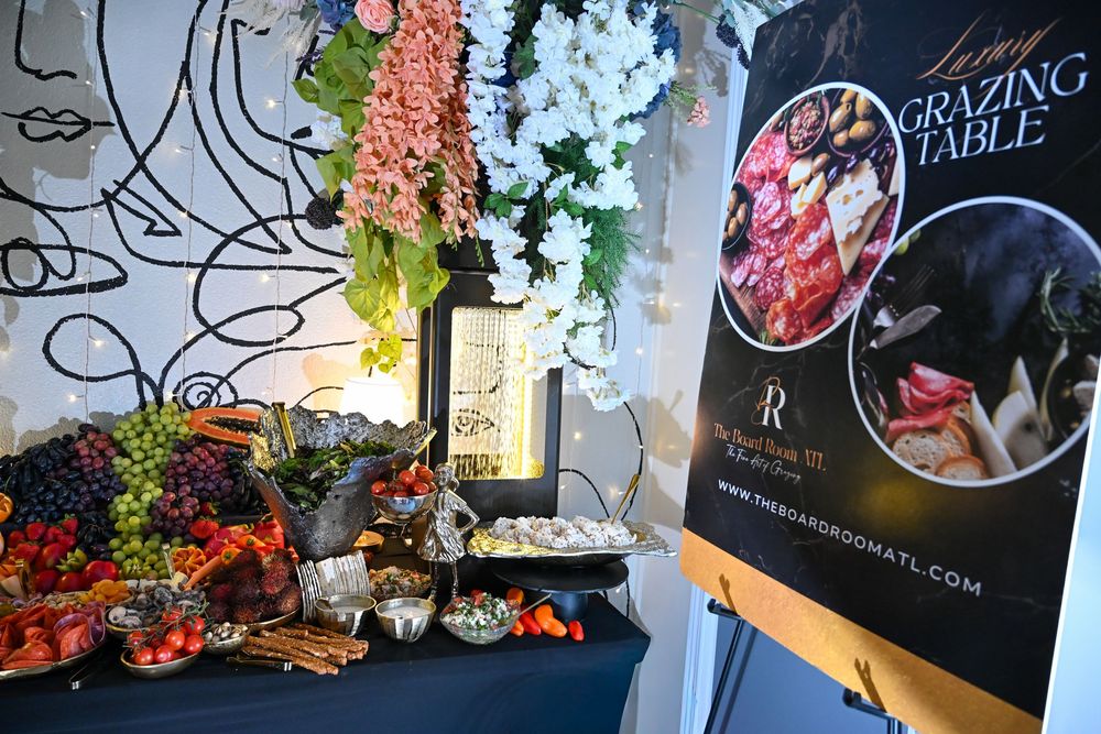 A wall decorated with illuminated string lights and colorful flowers surrounding a dining room setting.