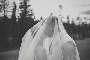 Bride and groom sharing a kiss under the veil during their Montana wedding