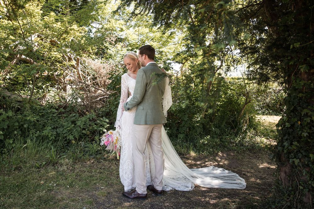 Wedding couple walking through lush garden pathways surrounded by greenery on their special day.
