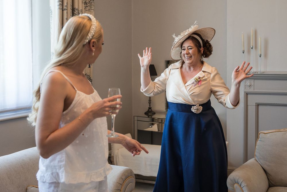 Two champagne glasses clink together during a celebratory toast at an indoor celebration.