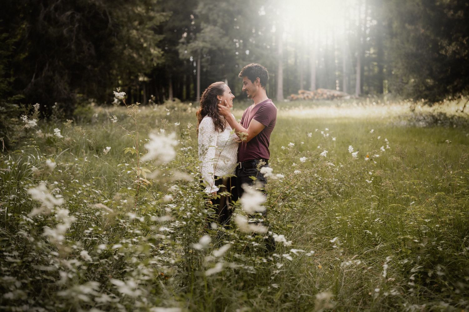 Dreamy backlit scene of people in wildflower field during golden hour.