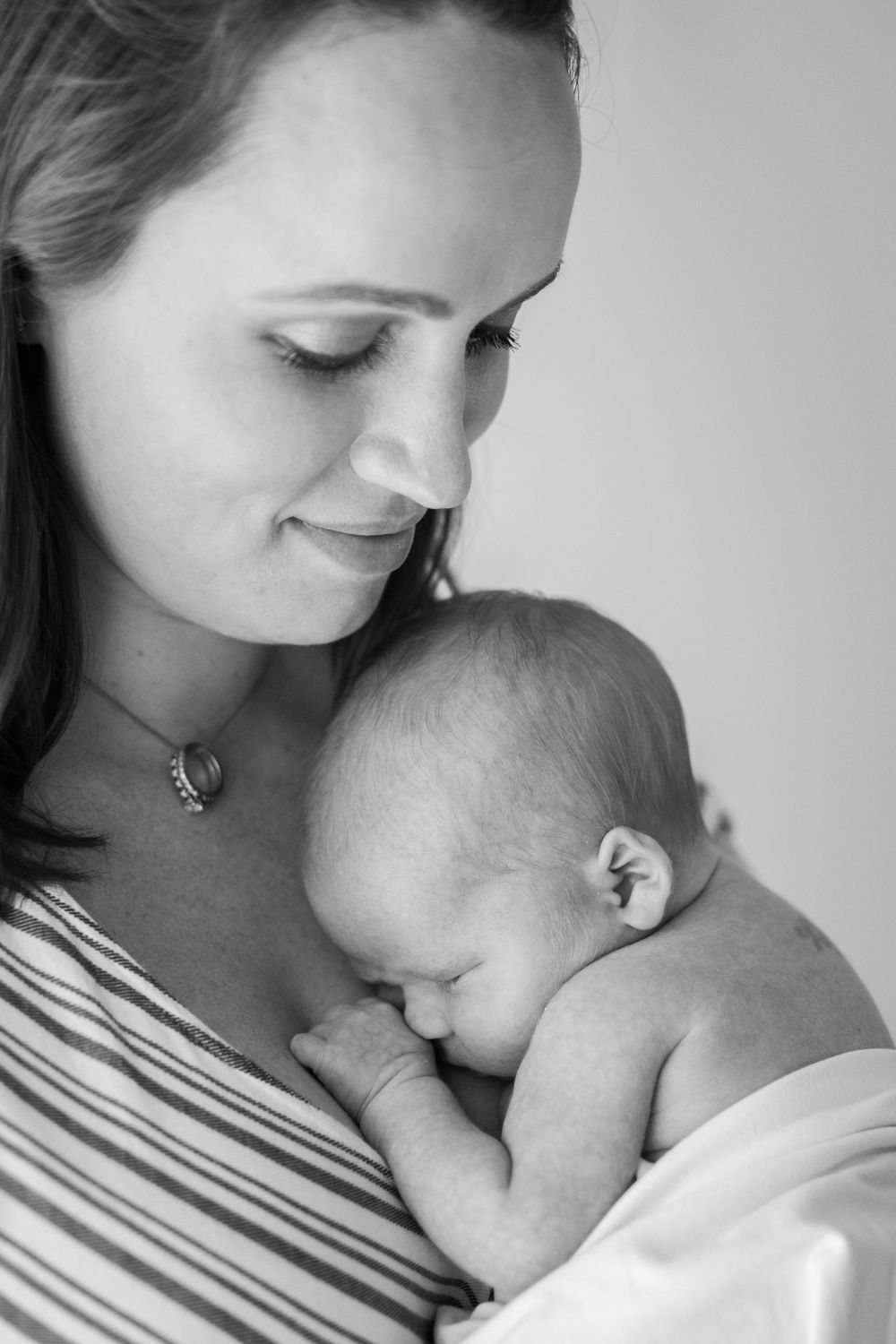 black and white photo of mom lovingly holding newborn son