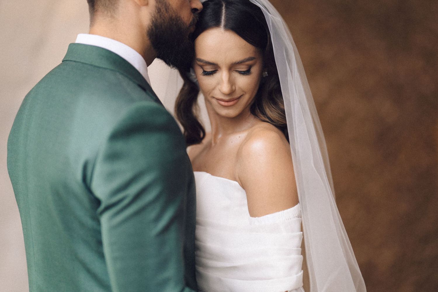 Romantic wedding couple shares intimate moments in a series of tender poses against a textured background.