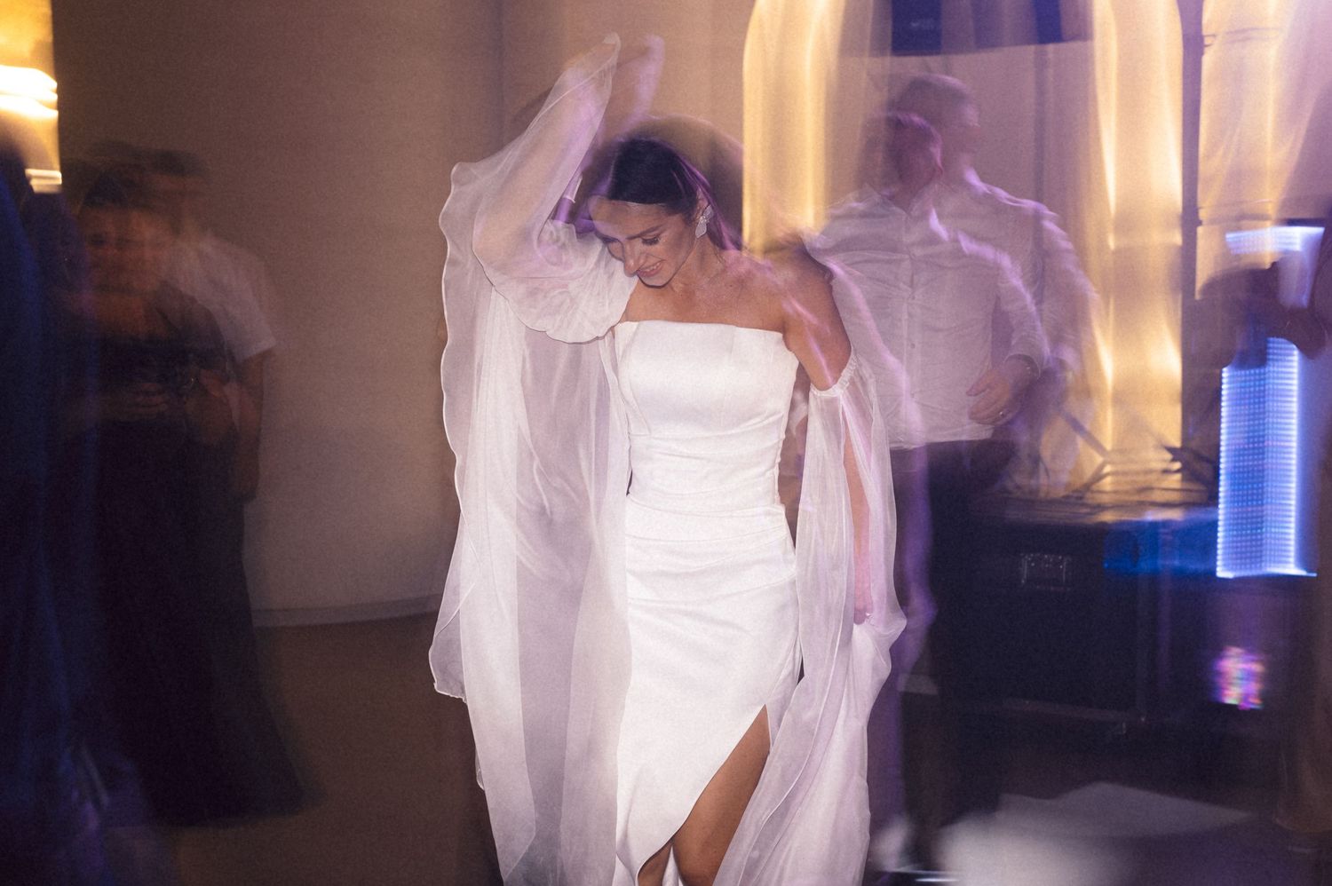 A ghostly figure in white fabric dances and moves through a dark room with blue lighting effects.