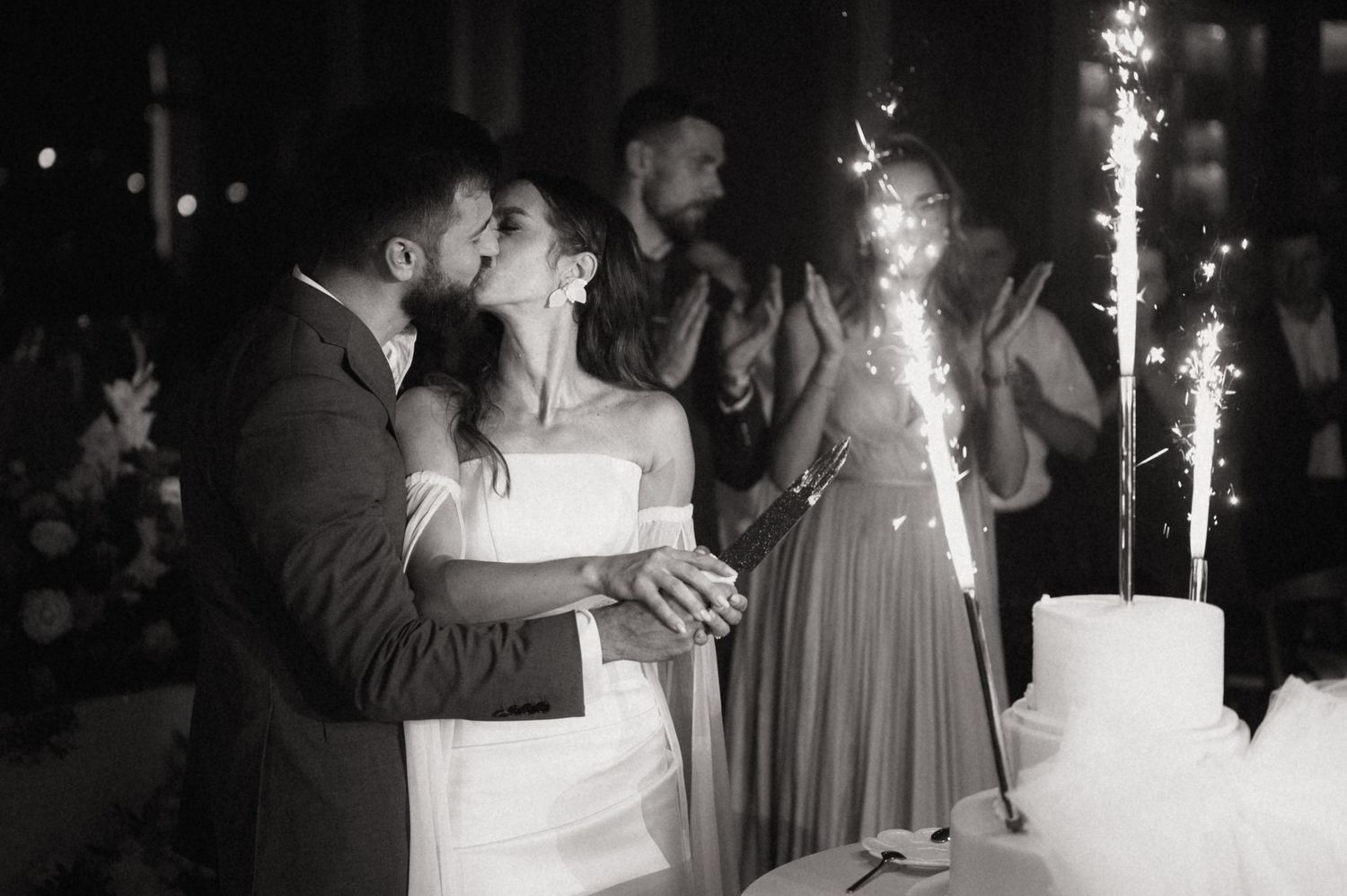 Sparklers illuminate a romantic wedding reception dance floor as guests celebrate in the evening.