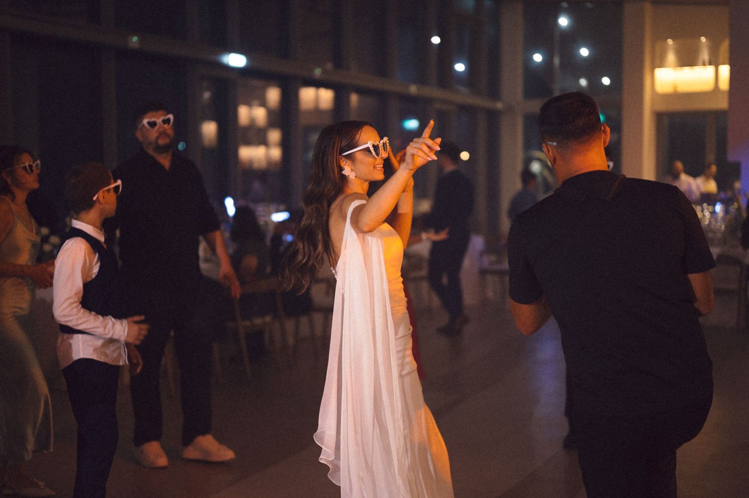 A couple dances together during a romantic evening celebration with warm lighting and festive atmosphere.