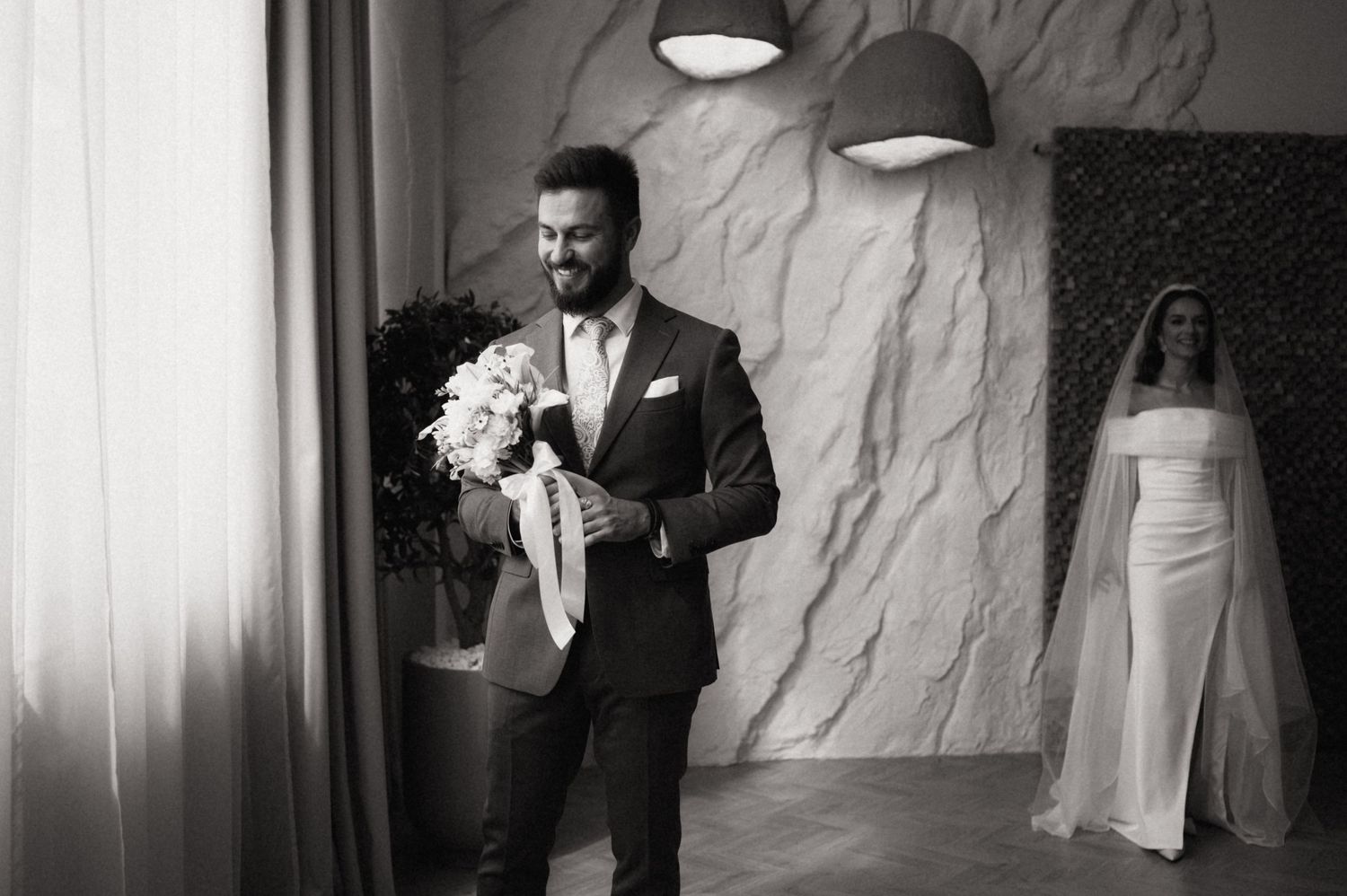Black and white wedding photos showing intimate moments between a couple in formal attire during their celebration.