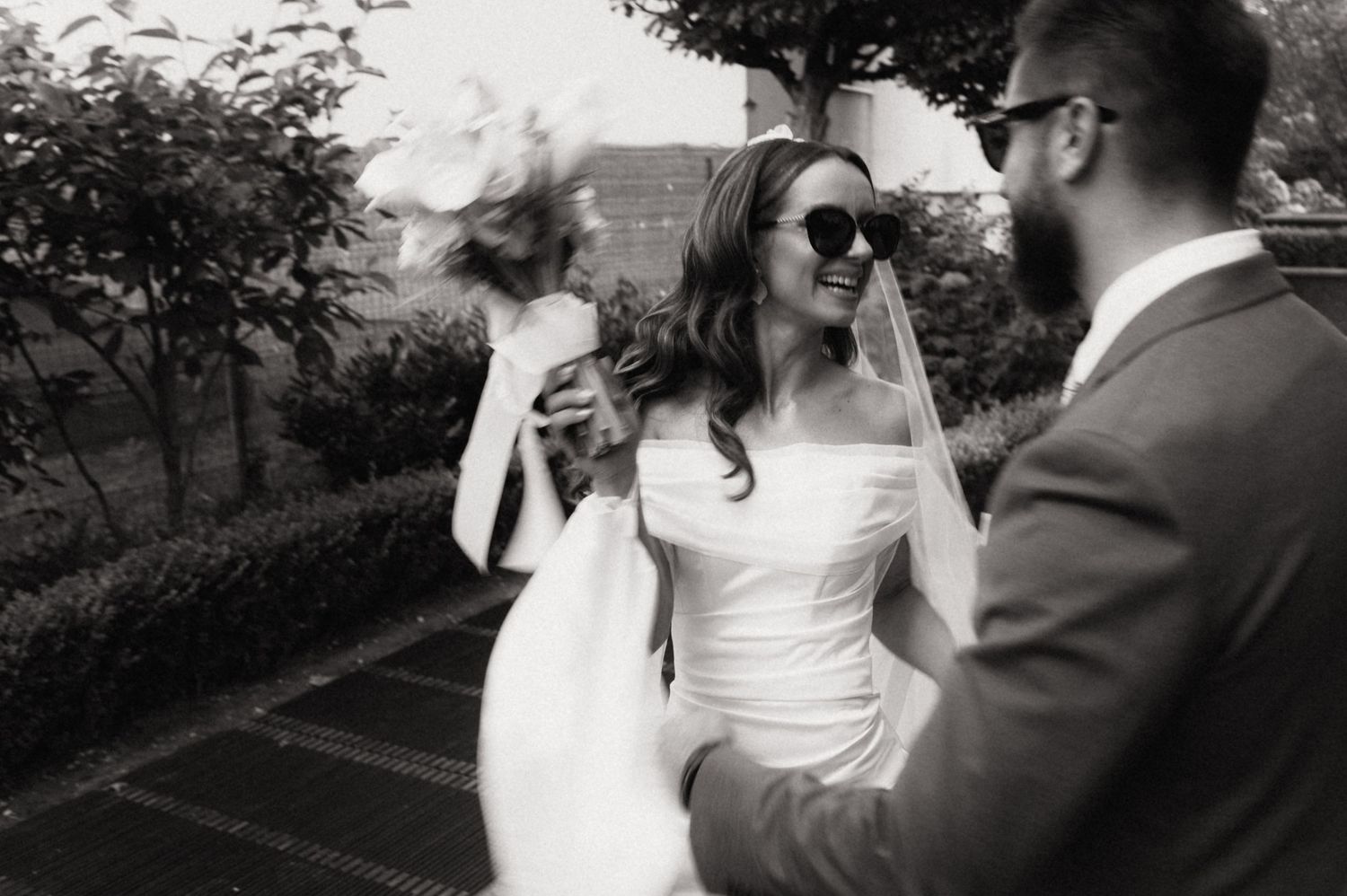 A couple shares a romantic moment outdoors during a wedding photo session in a garden setting.