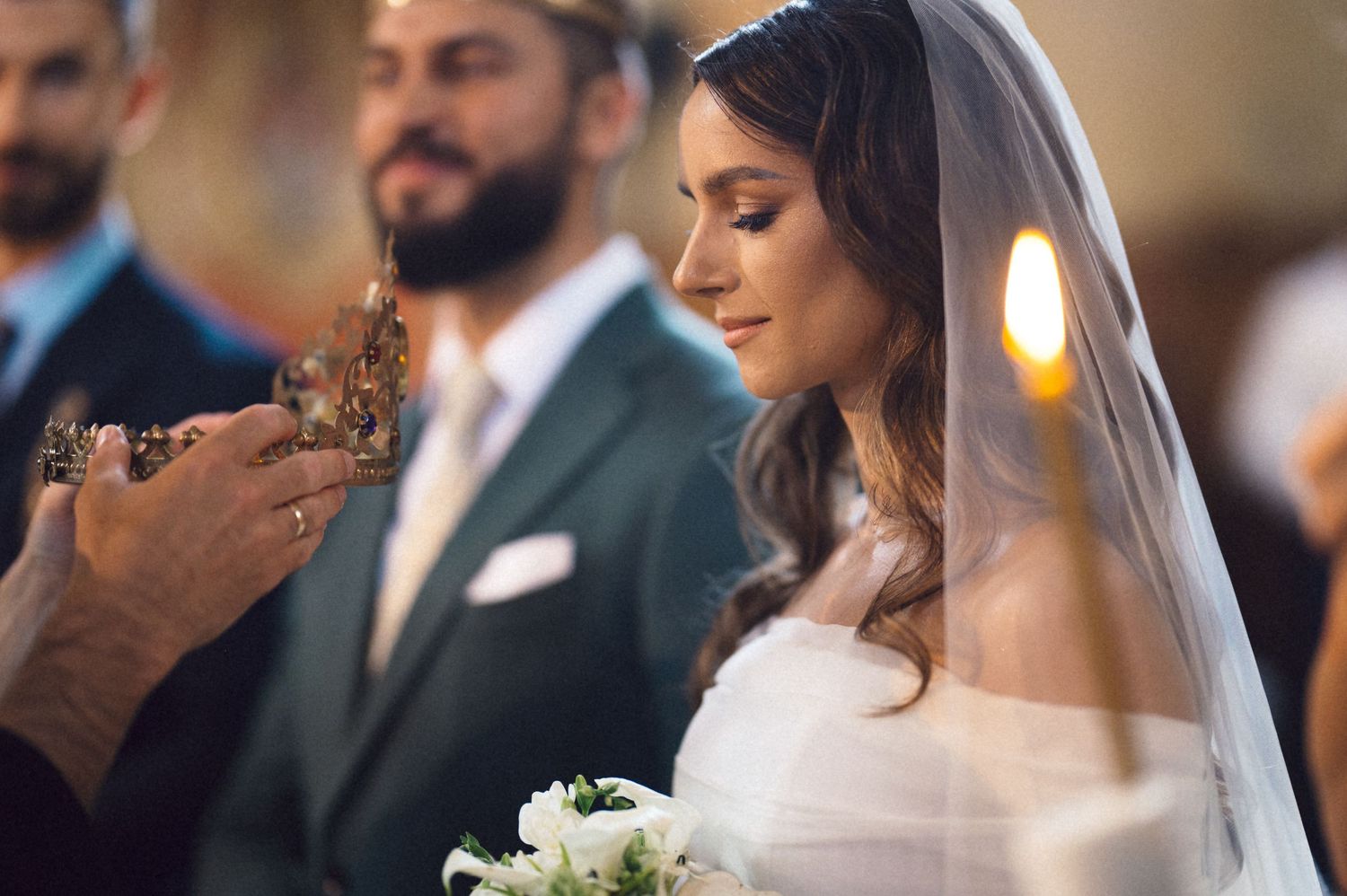 Bride and groom share an intimate moment during their wedding ceremony in a softly lit venue.