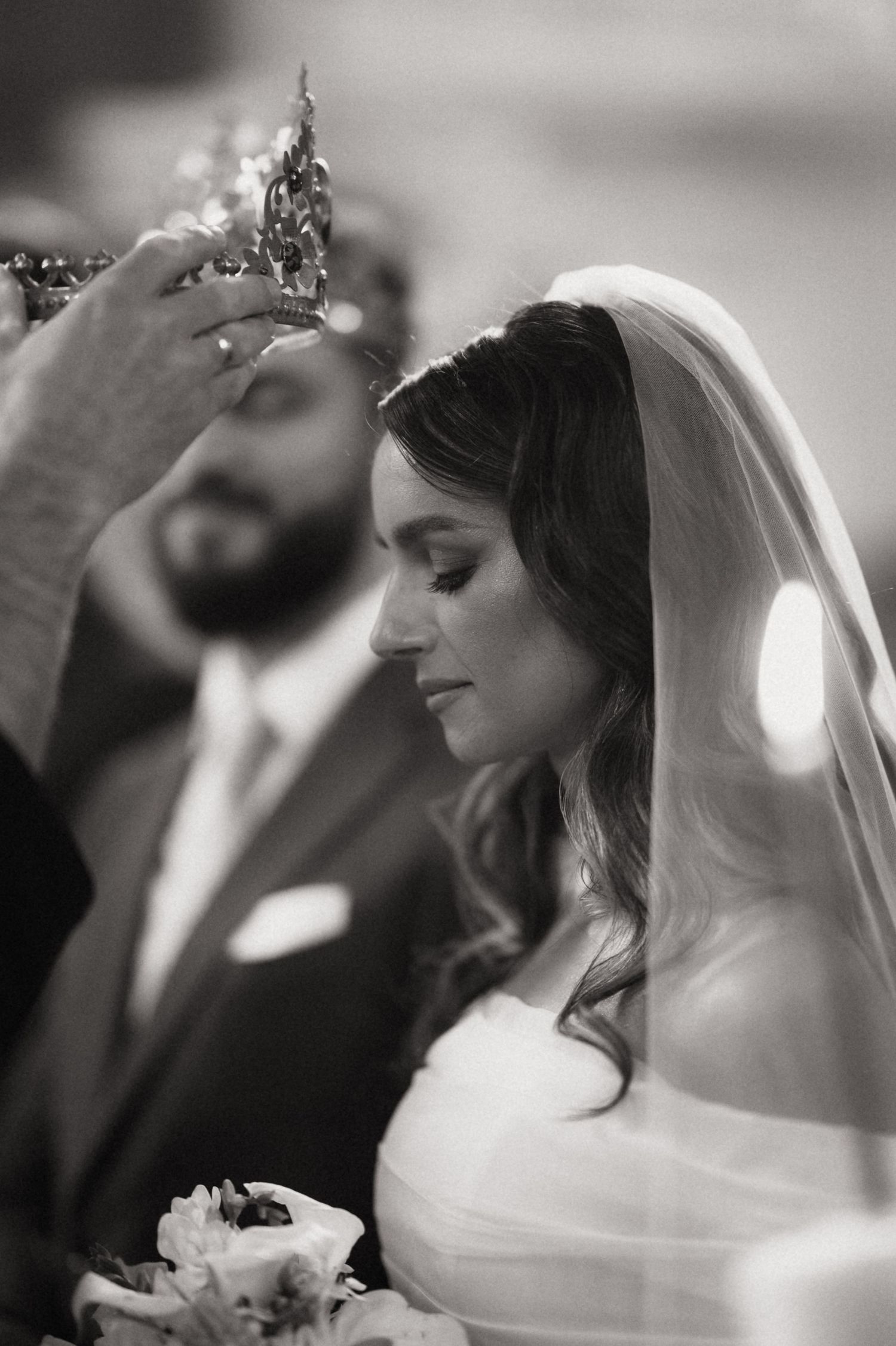 A black and white wedding photo series showing a bride in a white veil and dress looking to the side with a soft smile.
