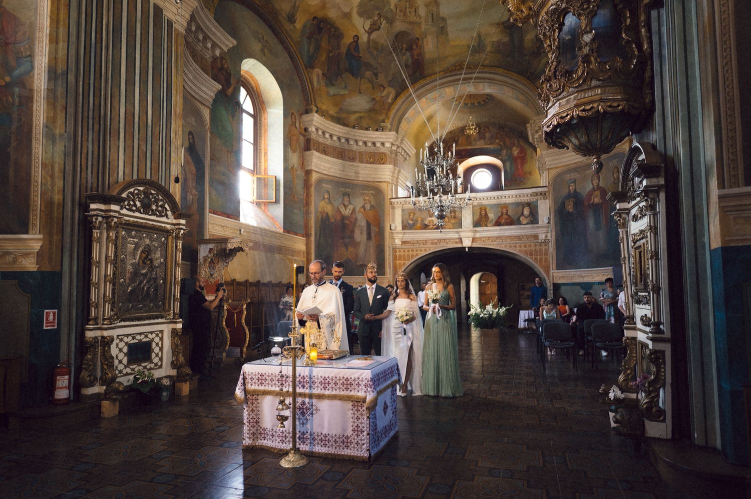 Interior view of an ornate baroque church with frescoed walls and ceilings showing multiple connected archways and chapels.
