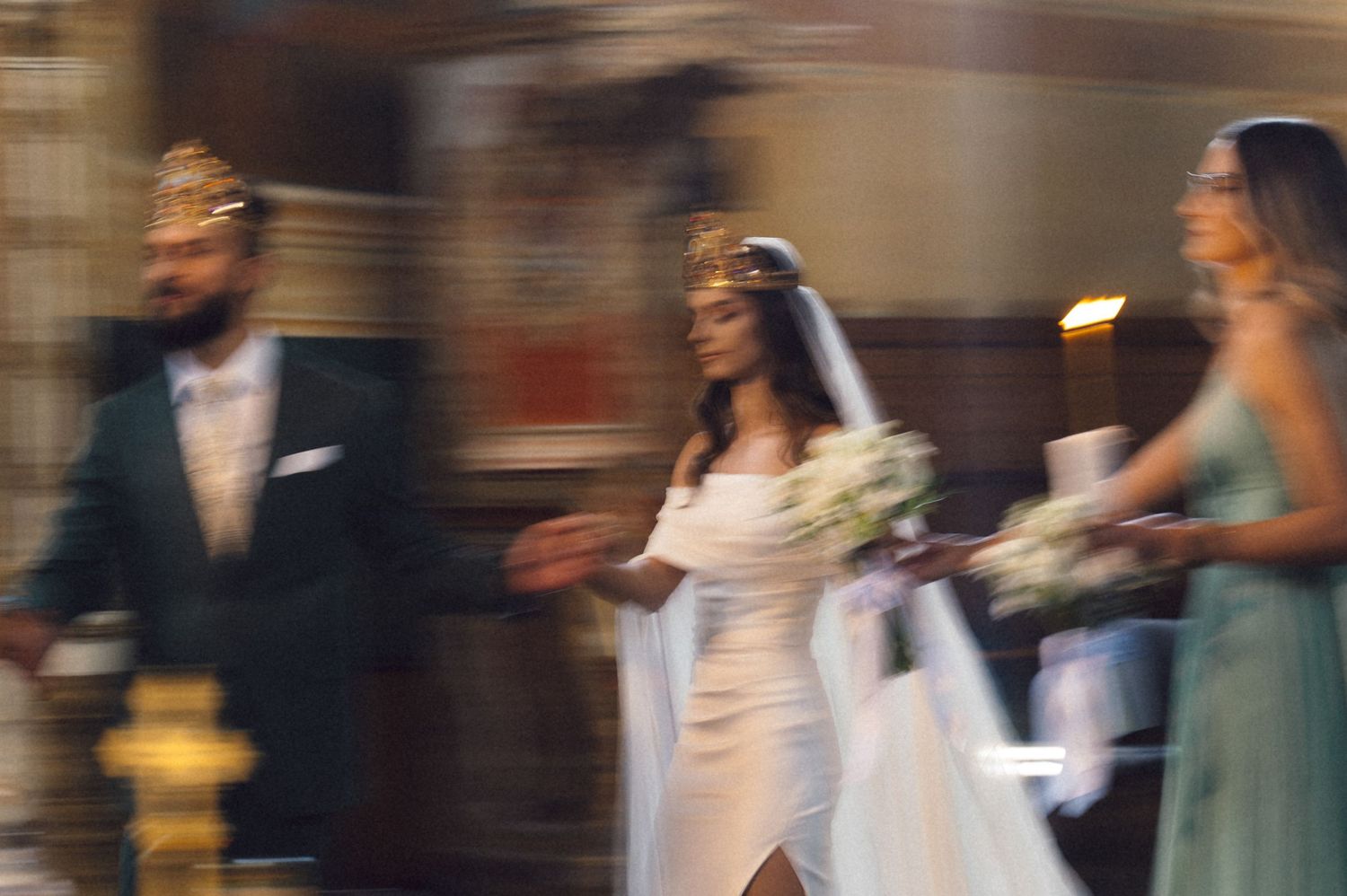 Blurred motion of wedding guests dancing and celebrating on a dimly lit dance floor at a reception.