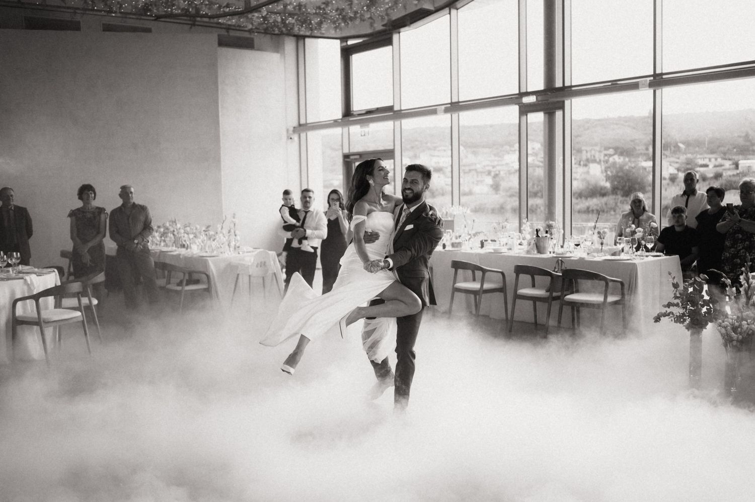 Dancers practicing in a bright dance studio with large windows, creating a dynamic and energetic atmosphere.