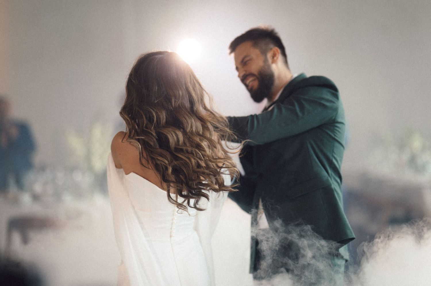 A couple dances intimately together in a romantic embrace with soft lighting and mist effects.