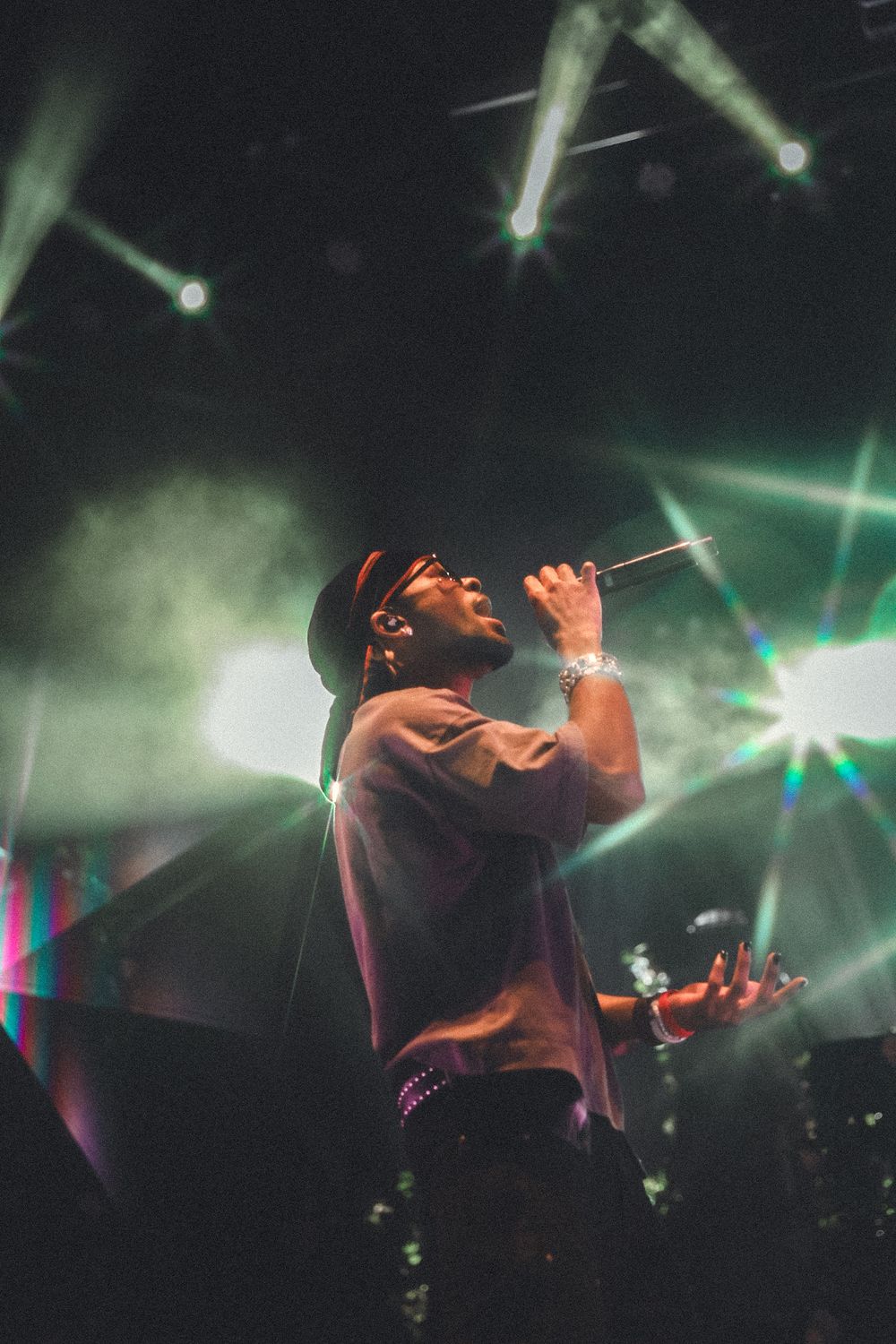 Artist performs passionately on stage with dramatic lighting and fog effects.