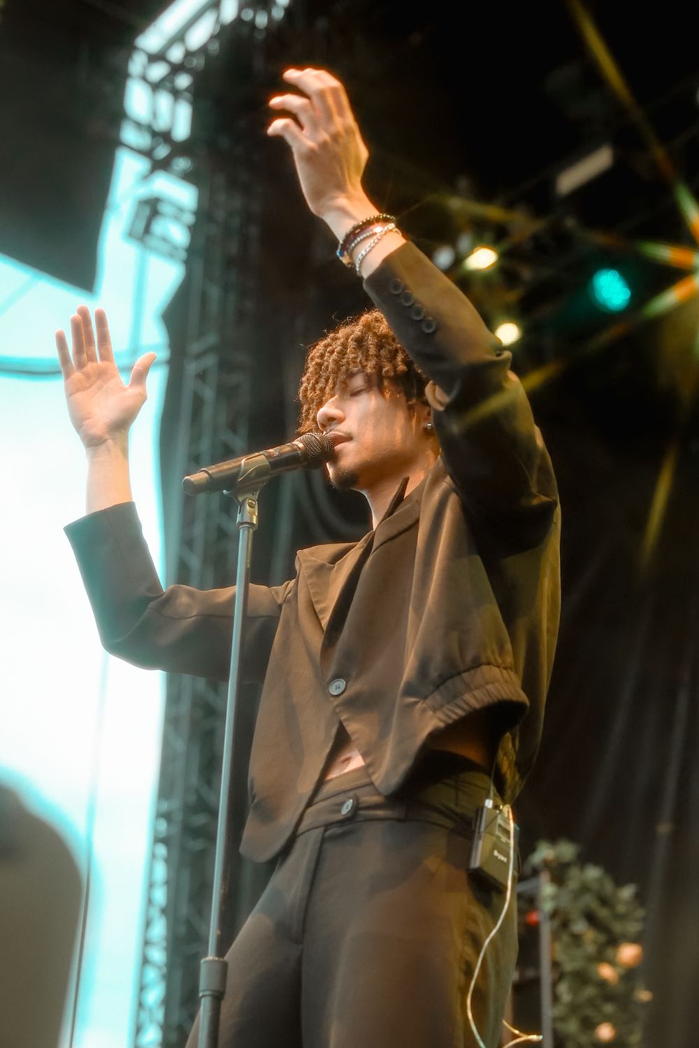 Bryant Barnes gestures dramatically under stage lighting during live performance.