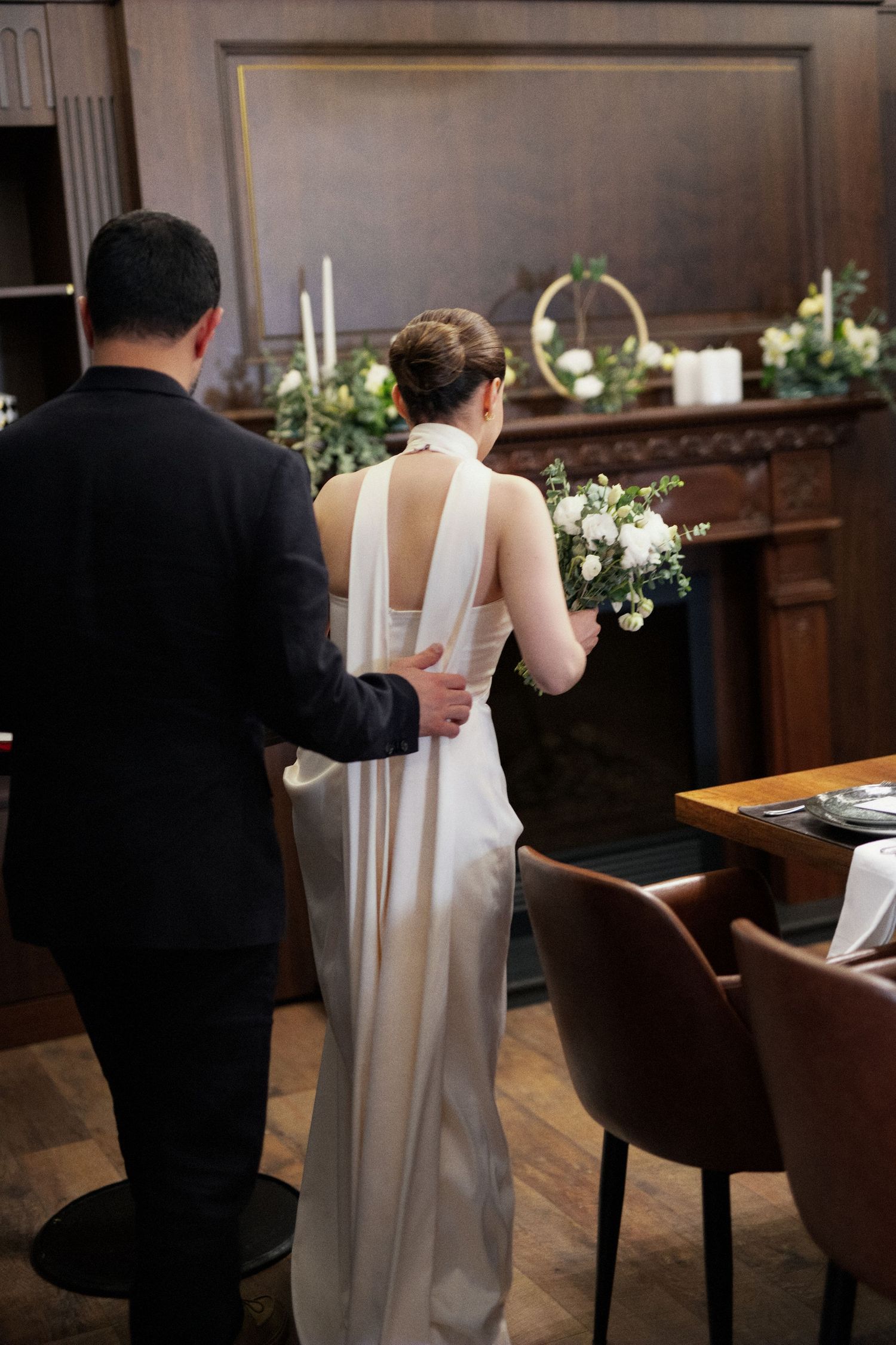 Couple sharing a romantic moment at a formal event, exchanging rings with roses in the background.
