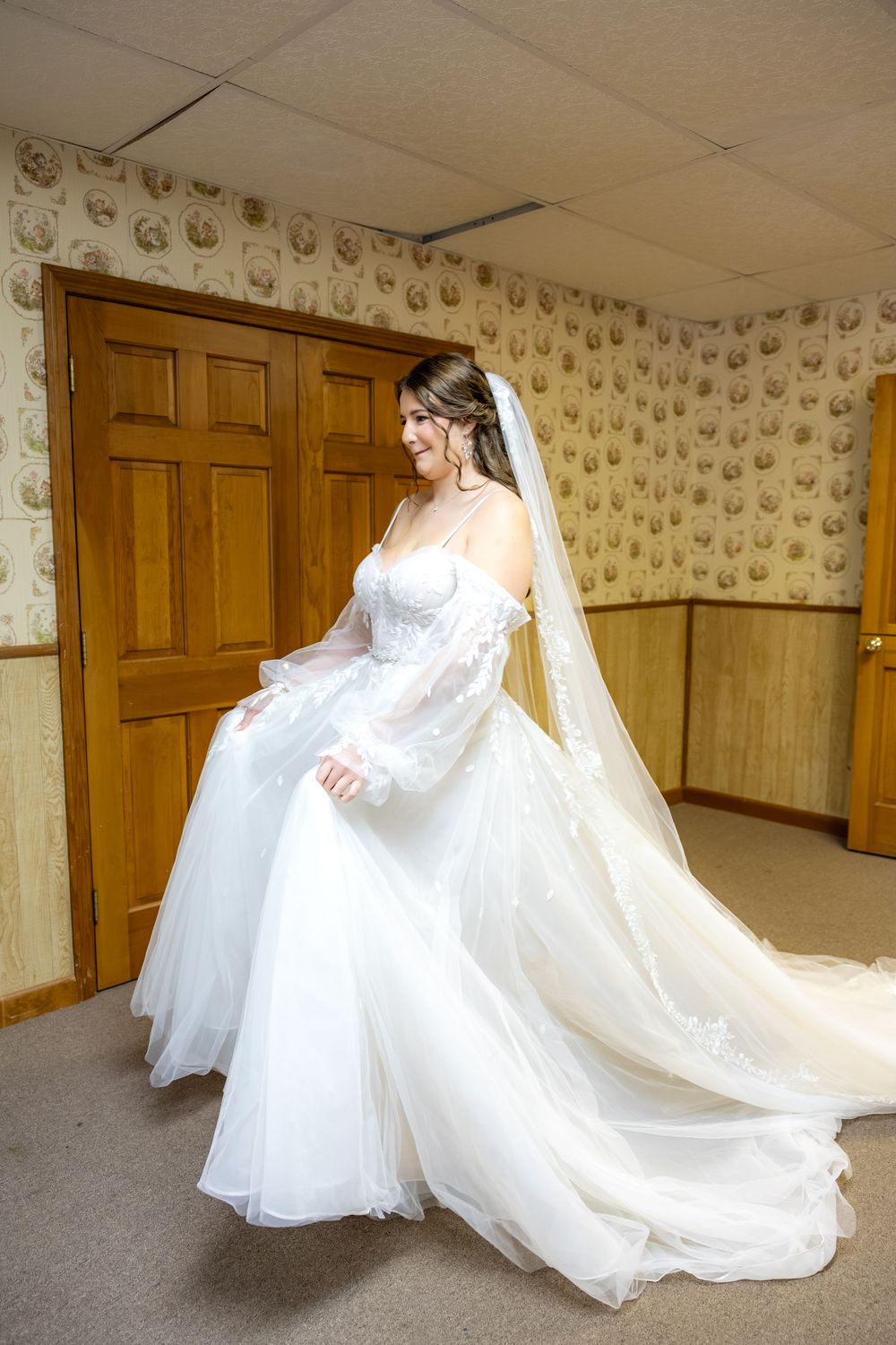 Bridal portraits showing the flowing movement and sweep of a long white wedding dress train and veil in a carpeted room.