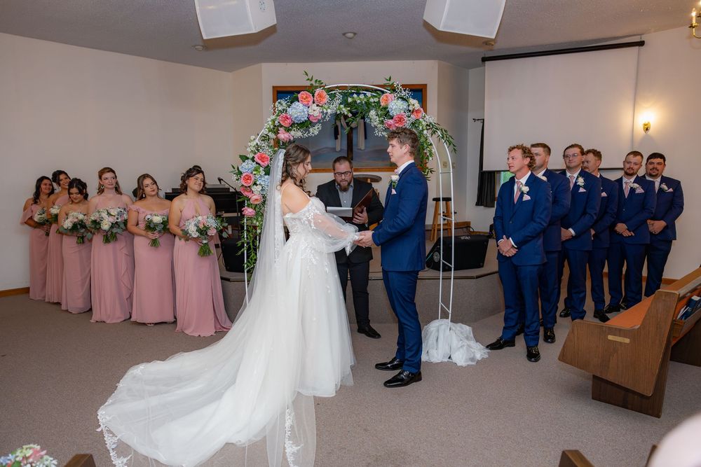 Collage of wedding ceremony moments showing elegant floral arch and guests in navy and pink attire.