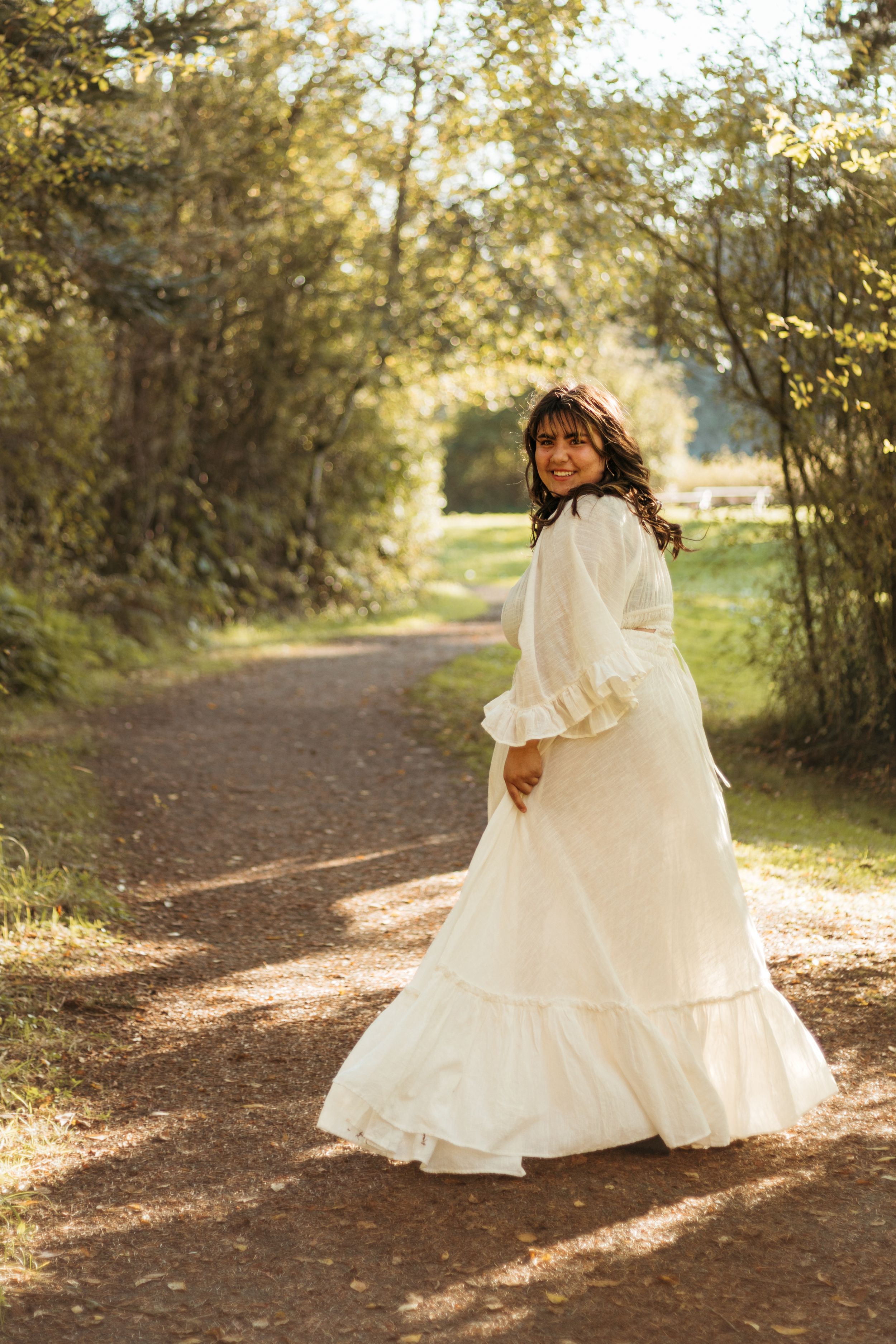 A series of photos showing a white dress flowing gracefully along a sunlit autumn forest path.