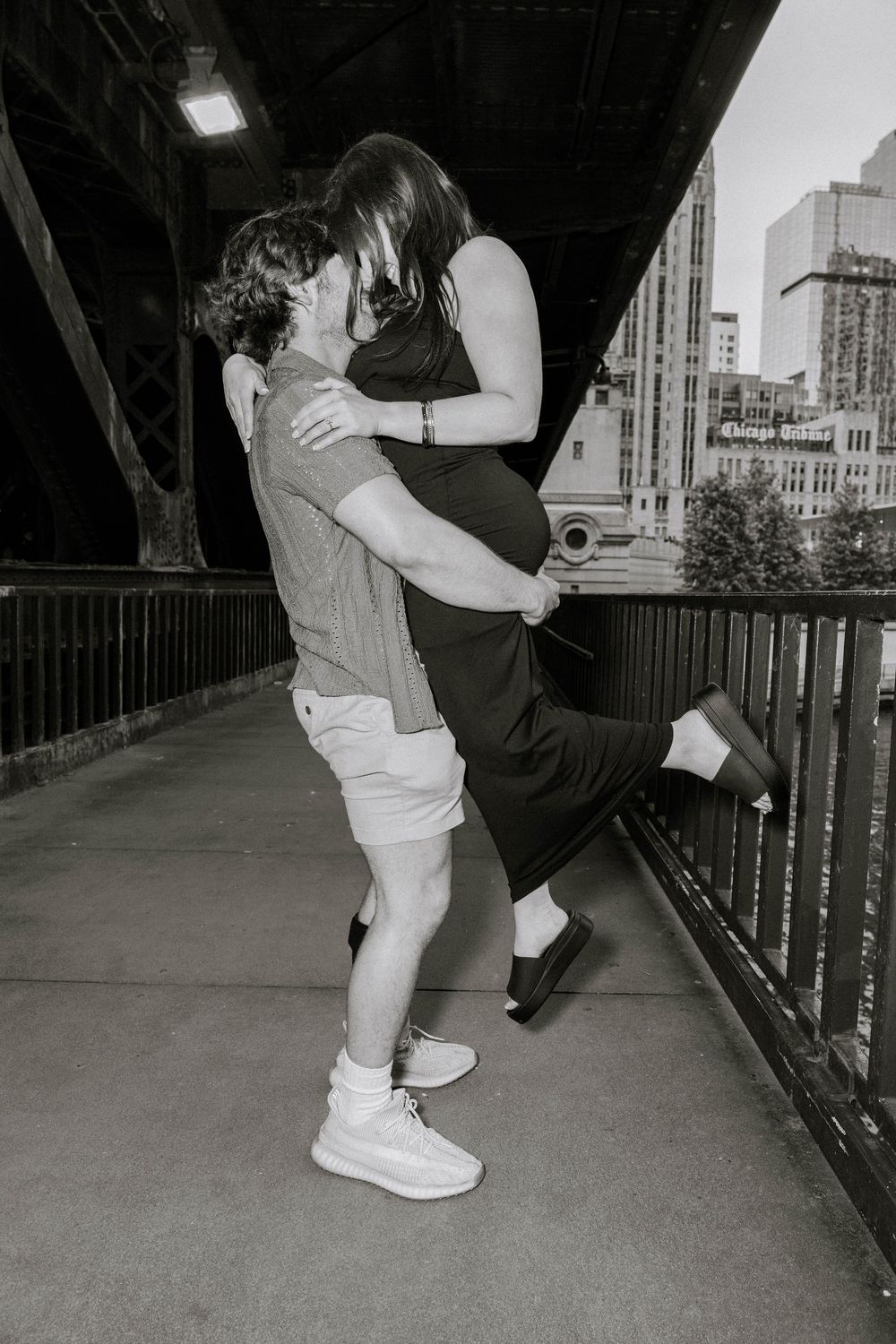Black and white photo sequence showing a couple dancing together in an intimate embrace on an urban bridge or walkway.