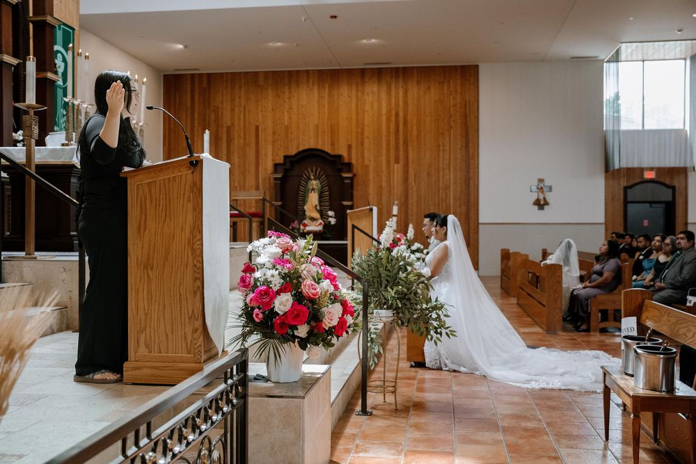 A wedding venue interior features wood paneled walls, elegant chandeliers and floral arrangements on display.