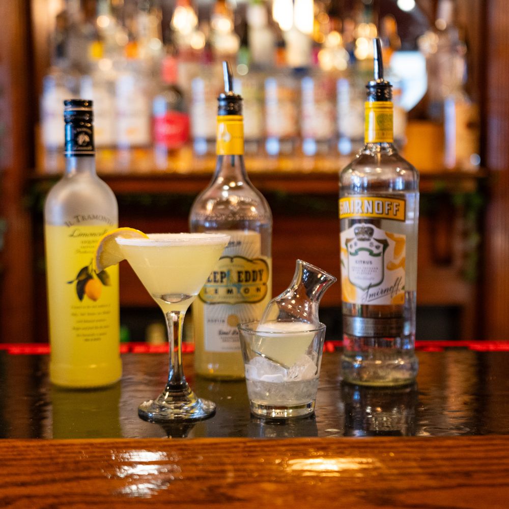 Smirnoff vodka and lemon liqueur cocktails served in martini glass at a bar.