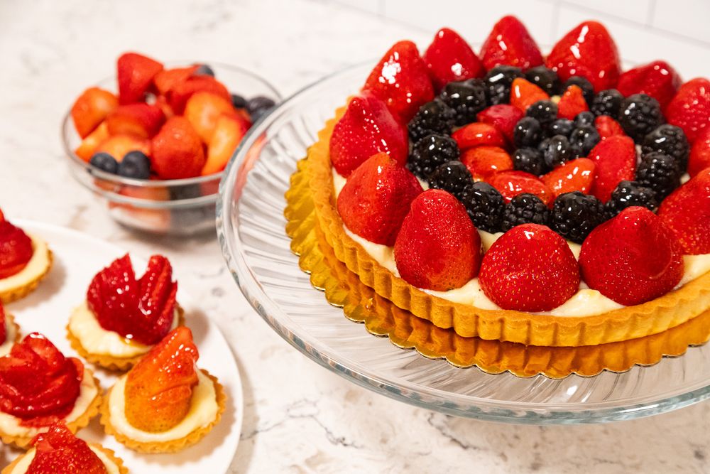 Fresh strawberries and blackberries arranged on top of a golden pastry tart in a circular pattern.