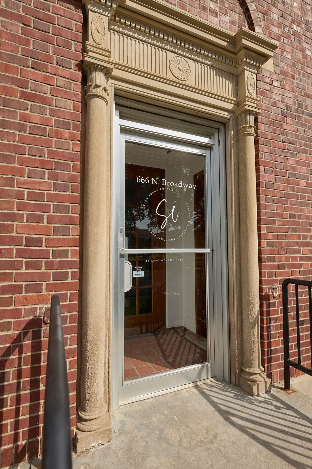 Historic brick building entrance with ornate stone trim and glass doors at 666 Broadway.