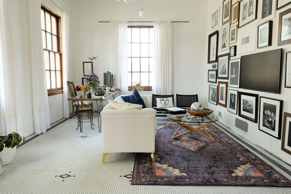Bright studio space with white walls adorned with black and white framed photographs and artwork.