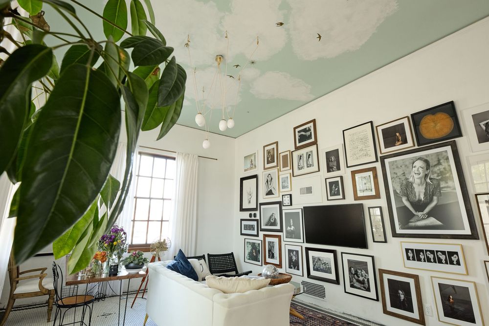 Modern art gallery-style room with mint green ceiling and multiple black and white photographs on display.