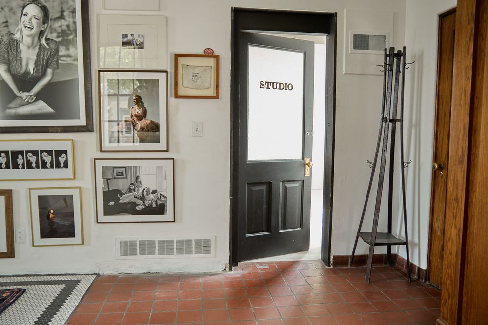 Gallery wall featuring black and white photographs in various frames with wooden door trim.