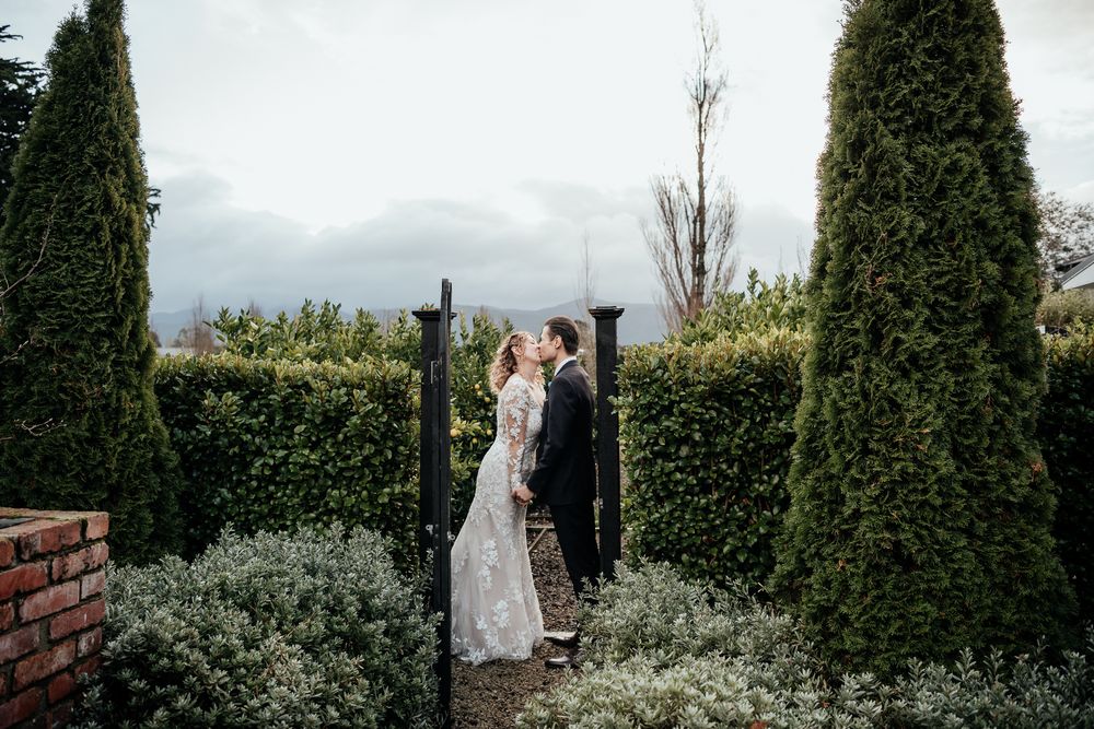 A bride and groom share a romantic moment in a beautiful garden setting during their Greytown elopement by August & Vine