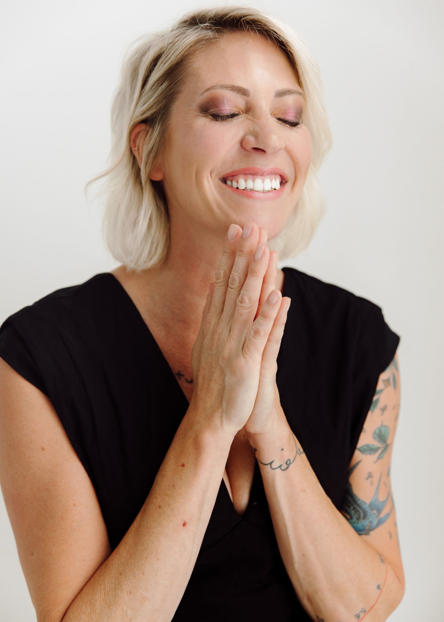 A series of joyful expressions and laughter captured in black and white portraits against a light background.