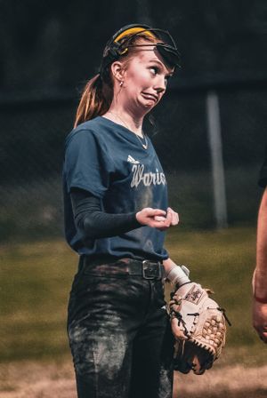 Softball player wearing visor and navy uniform holds glove while standing on field.
Softball riverside high school kanawha county