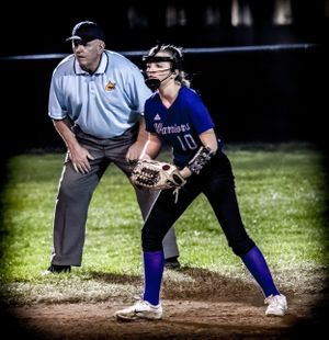 Softball infielder in defensive stance as umpire watches from behind during night game.
Softball riverside high school kanawha county