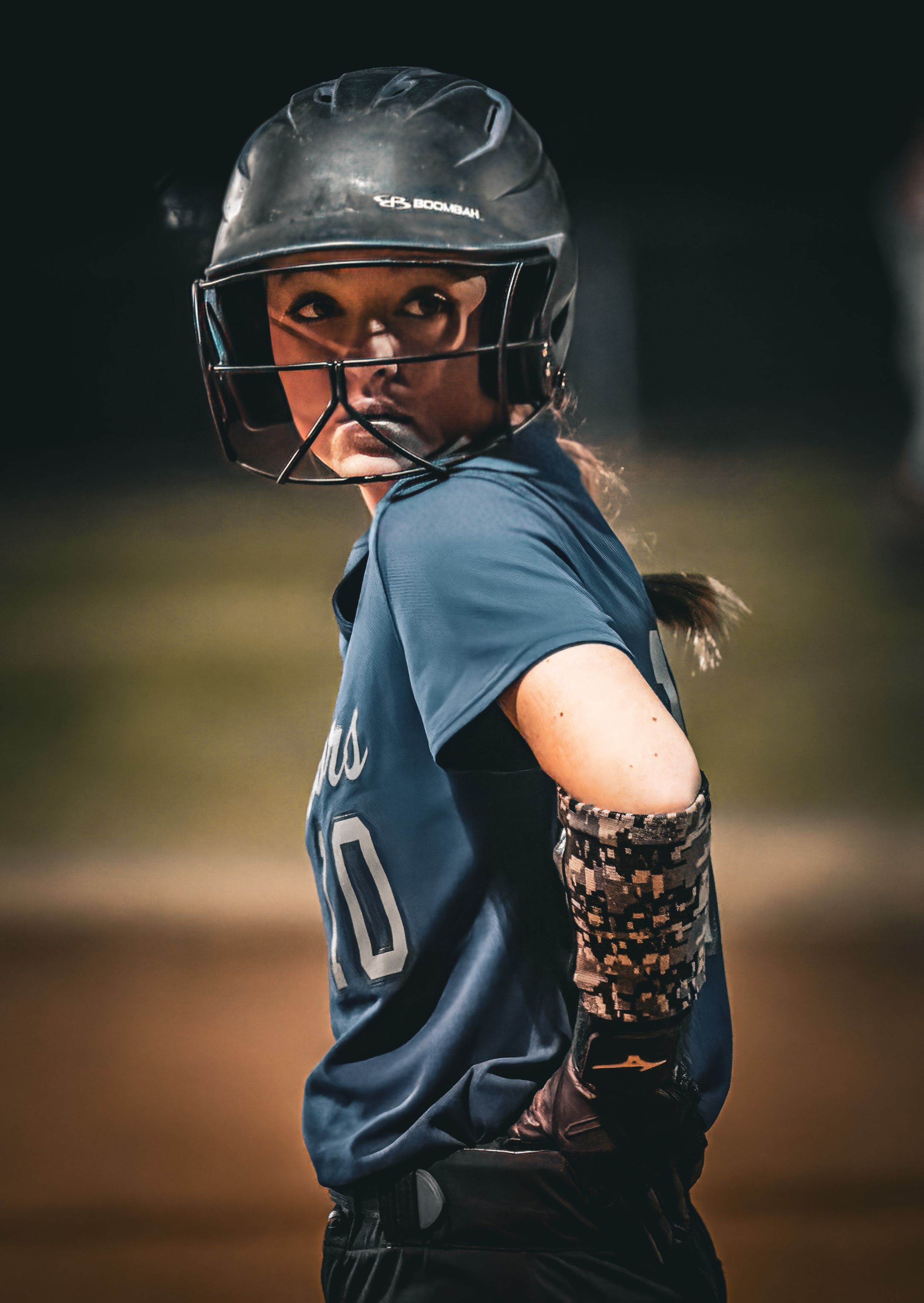 Softball player in navy uniform looks over shoulder while wearing protective batting helmet.\
Softball riverside high school kanawha county