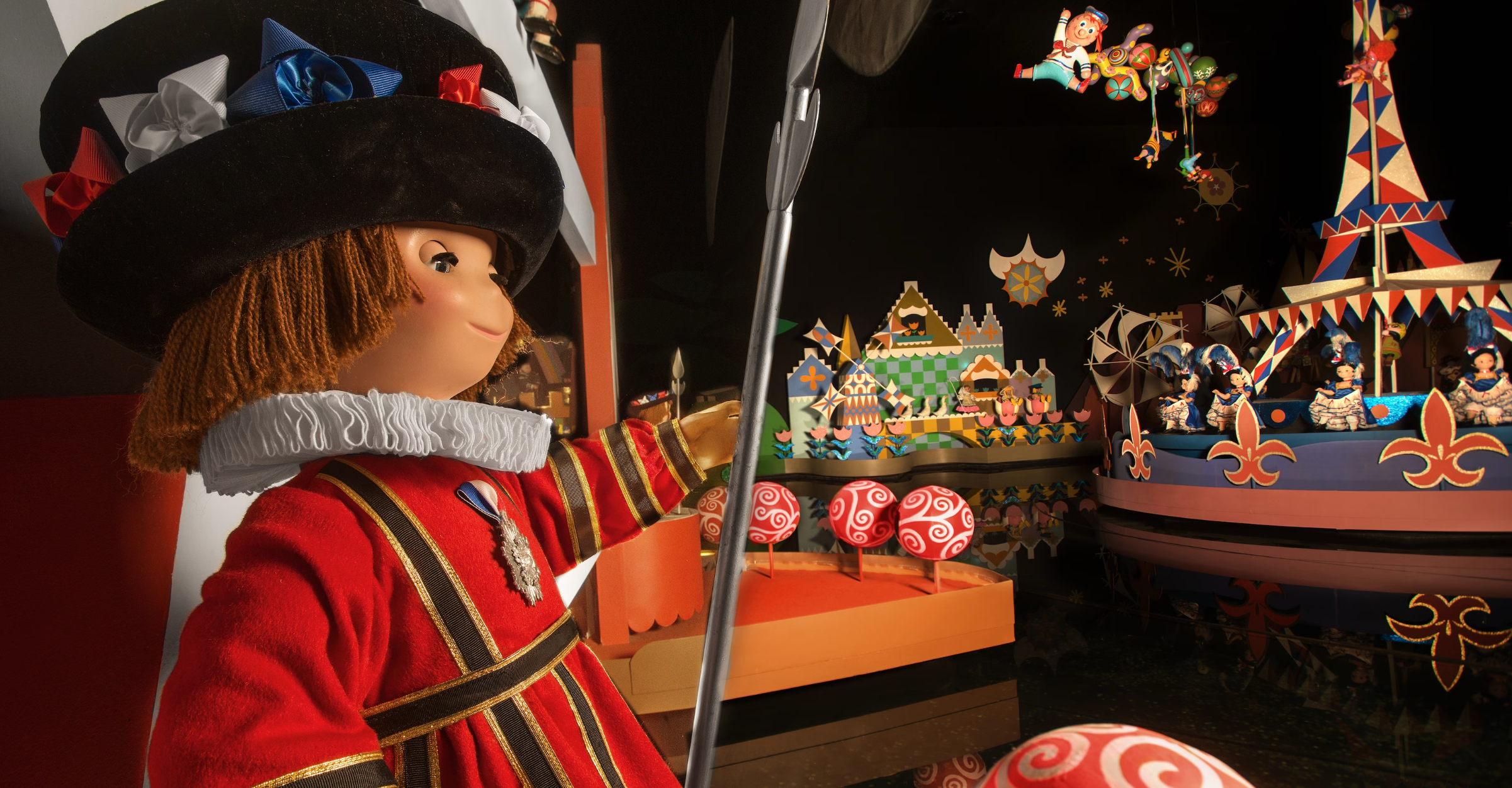 A festive Christmas scene with a decorative figure in red attire admiring colorful carousel displays with ornate details.