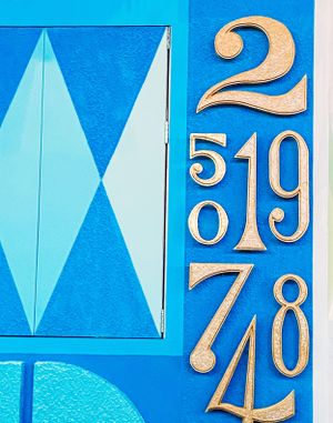Numbers in gold color cut from foam or paper arranged on vivid blue background in organized sequence pattern.