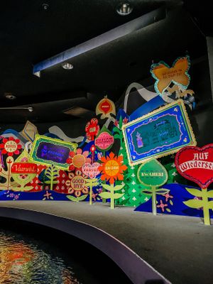 Colorful illuminated floral design displays with lights create a whimsical outdoor garden scene at night.