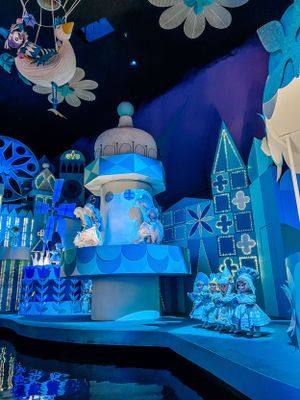 A whimsical theme park attraction featuring blue and white decorative elements with illuminated castle-like structures at night.
