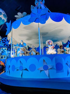 Inside Disney's It's a Small World ride featuring illuminated blue decor and animatronic figures in polar-themed scenes.