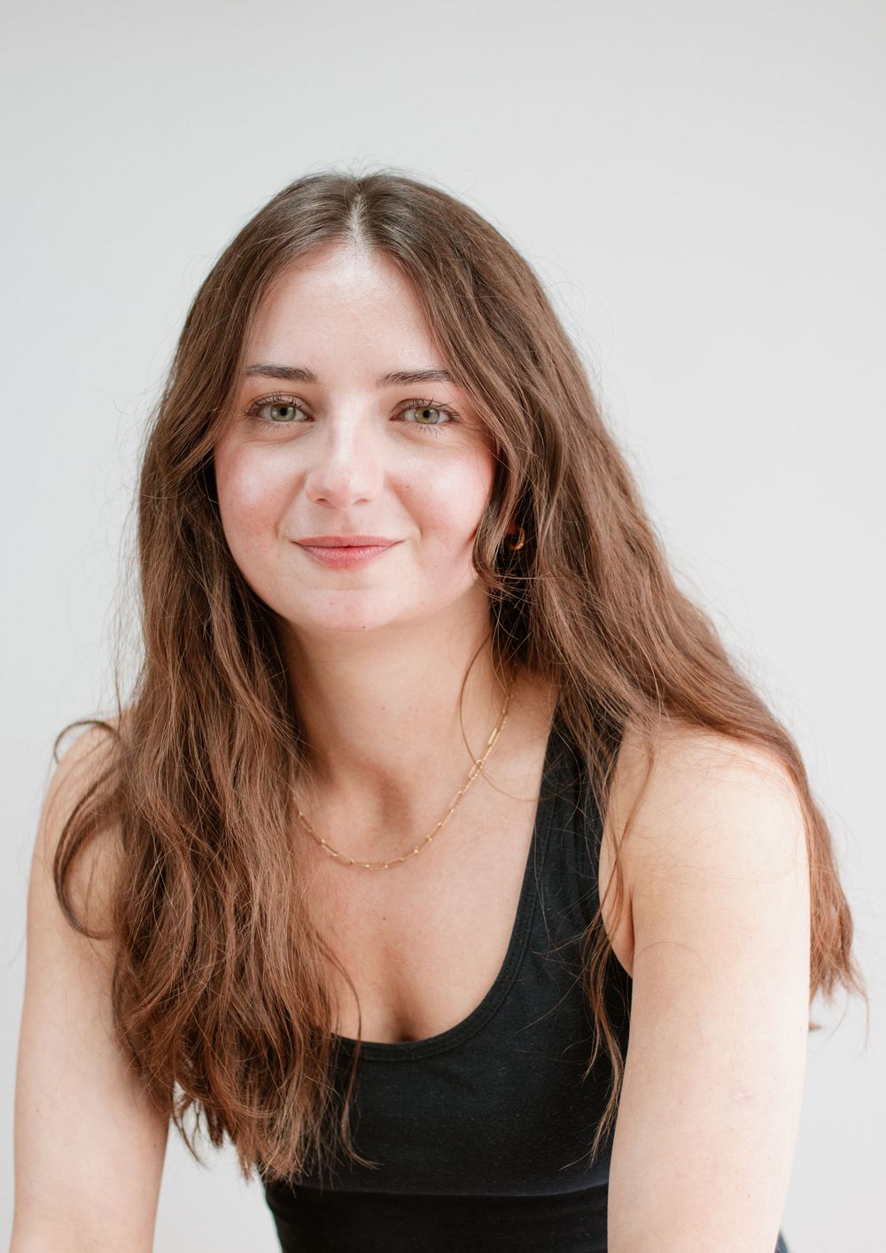 Studio portrait of a person in a black top against a white background.