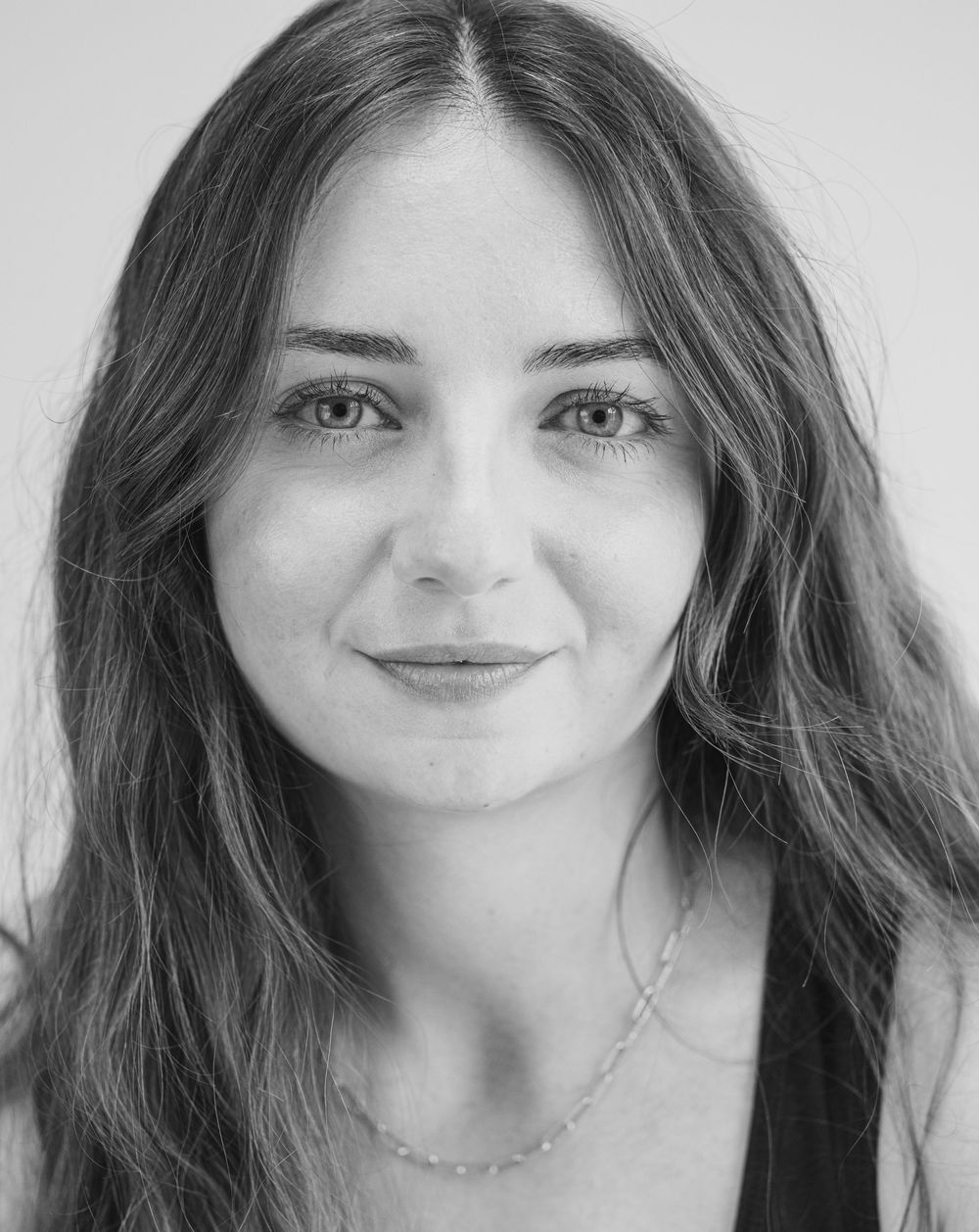 Black and white headshot portrait with soft lighting and natural expression.