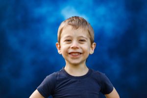 School portrait showing a happy expression against a blue mottled background.
