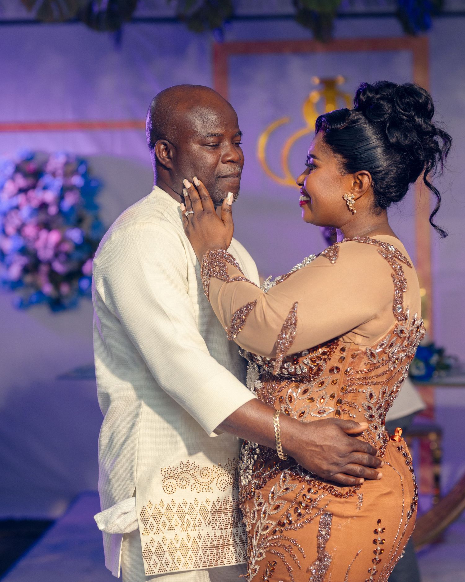 Intimate moment captured during a wedding reception with champagne-colored formal attire.