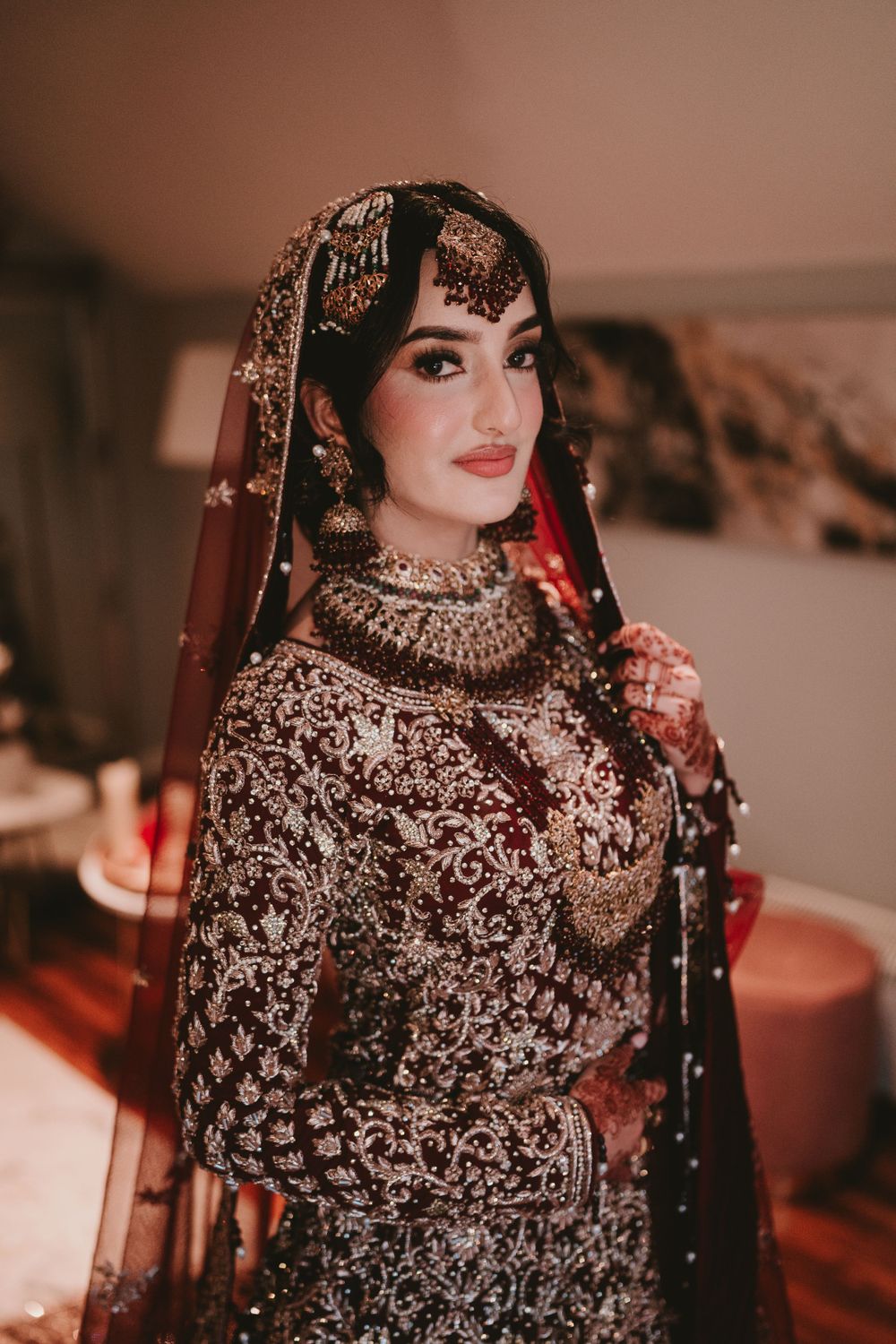 Traditional South Asian bridal attire featuring intricate embroidery and jeweled headpiece.