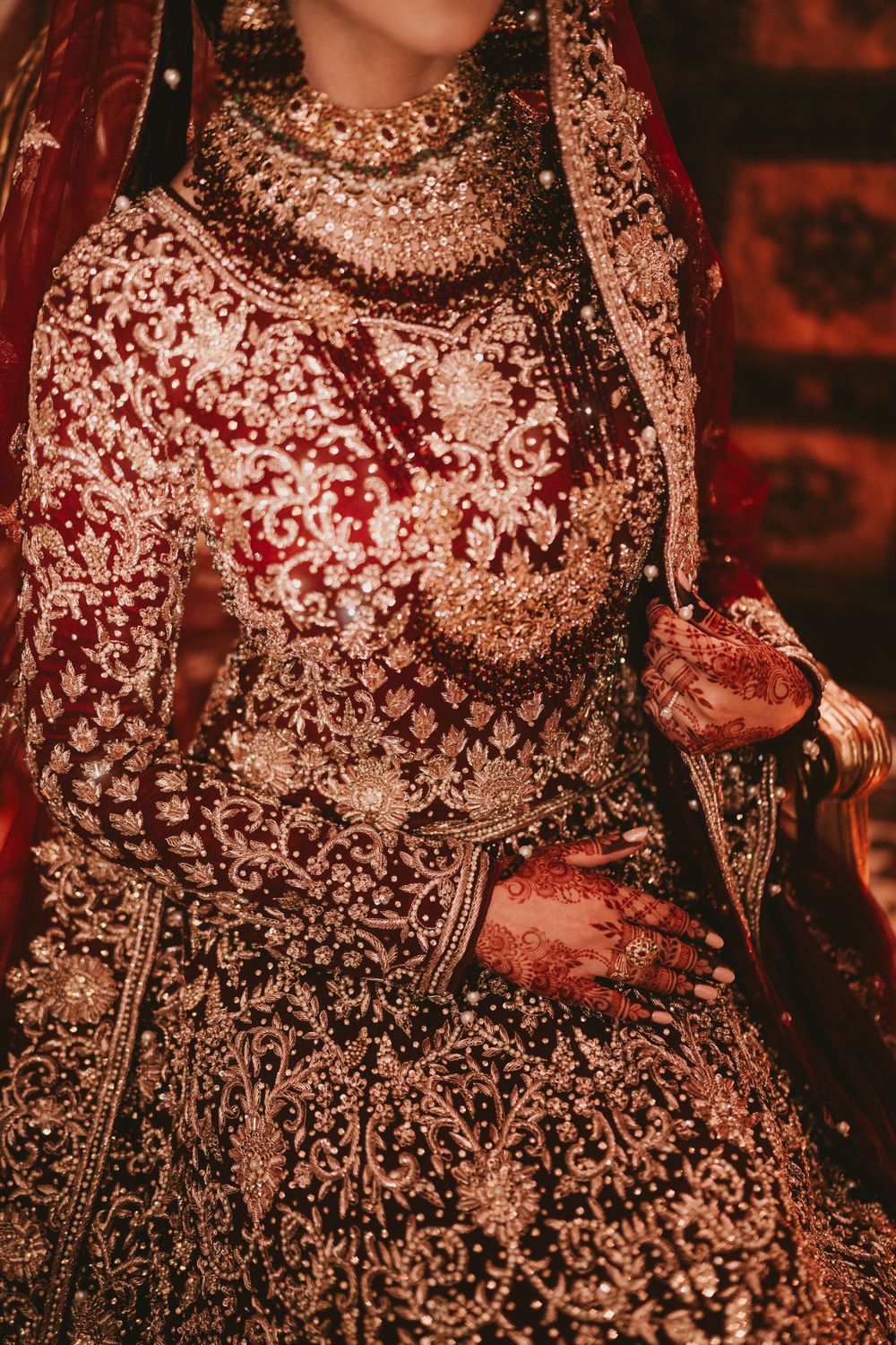 Detailed view of a heavily embellished burgundy and gold South Asian wedding lehenga.