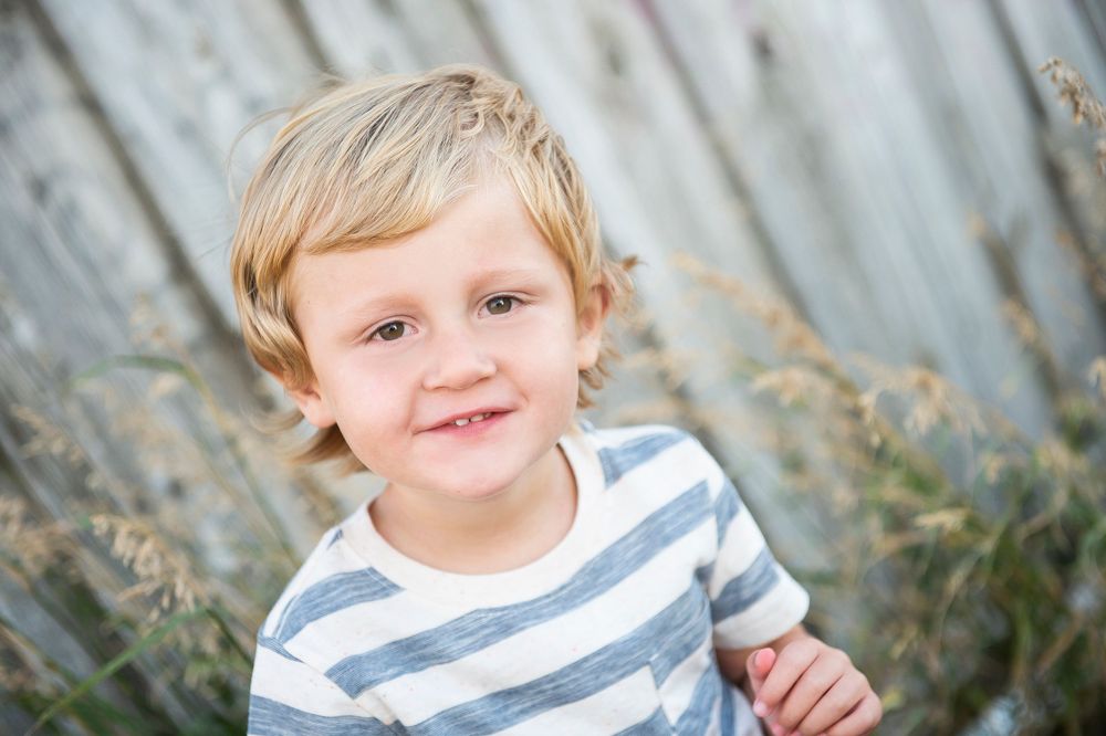 Close up outdoor portrait with a striped shirt against a soft neutral background.