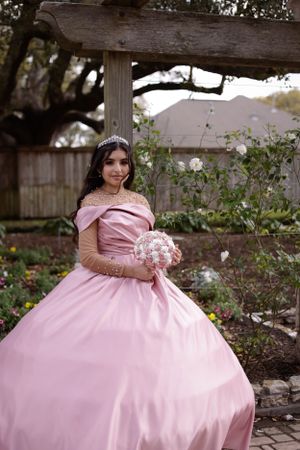 sweet sixteen outdoor portrait holding pink bouquet.